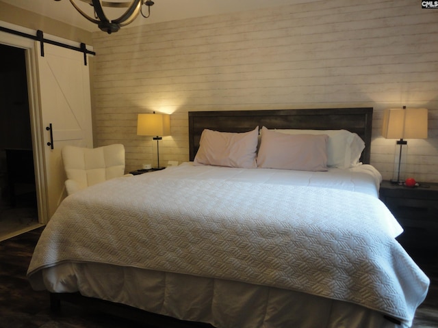 3909 E Peach Rd, Ridgeway, SC 29130 - bedroom featuring a barn door, wood finished floors, and wood walls
