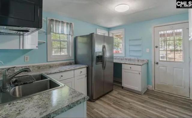 3909 E Peach Rd, Ridgeway, SC 29130 - kitchen featuring stainless steel refrigerator with ice dispenser, white cabinetry, light wood-style floors, and healthy amount of natural light