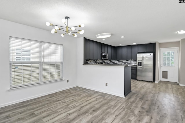 339 Bracken Dr, Lexington, SC 29072 - kitchen with stainless steel appliances, a chandelier, light wood finished floors, a peninsula, and recessed lighting