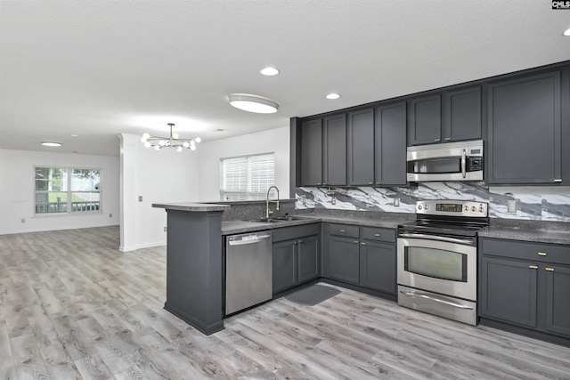 339 Bracken Dr, Lexington, SC 29072 - kitchen with stainless steel appliances, a chandelier, a peninsula, dark countertops, and recessed lighting