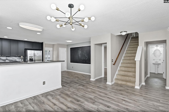 339 Bracken Dr, Lexington, SC 29072 - unfurnished living room with a textured ceiling, stairway, light wood-style floors, a chandelier, and recessed lighting