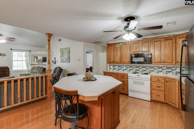 1162 Whippoorwill Rd, Camden, SC 29020 - kitchen with black appliances, ceiling fan, light countertops, light wood-style flooring, and a kitchen island