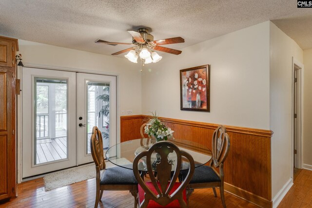 1162 Whippoorwill Rd, Camden, SC 29020 - dining area with light wood-style flooring, a wainscoted wall, ceiling fan, a textured ceiling, and french doors