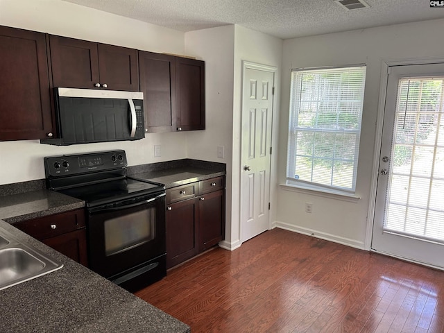 206 Windsor Village Dr, Columbia, SC 29223 - kitchen featuring stainless steel microwave, black range with electric cooktop, dark countertops, dark wood finished floors, and a textured ceiling