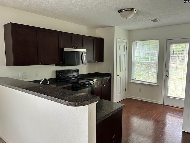206 Windsor Village Dr, Columbia, SC 29223 - kitchen featuring stainless steel microwave, black range with electric stovetop, dark countertops, dark wood-style floors, and dark brown cabinetry