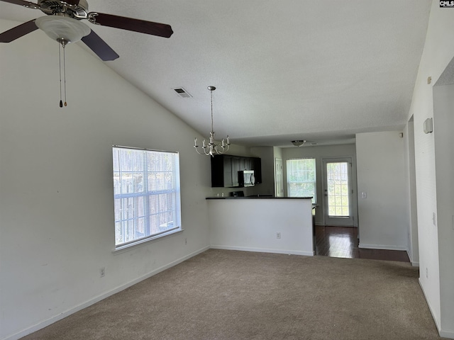 206 Windsor Village Dr, Columbia, SC 29223 - unfurnished living room featuring dark colored carpet, a ceiling fan, a chandelier, and vaulted ceiling