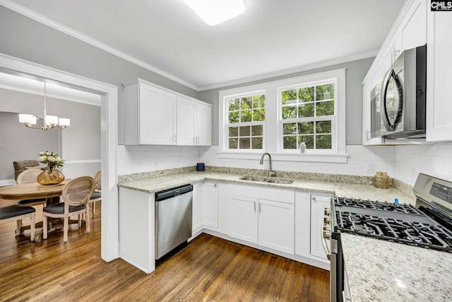 2625 Harrison Rd, Columbia, SC 29204 - kitchen featuring appliances with stainless steel finishes, ornamental molding, dark wood-style flooring, white cabinetry, and a chandelier