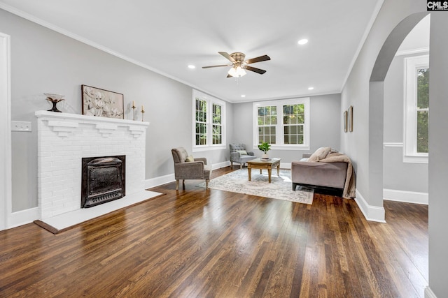 2625 Harrison Rd, Columbia, SC 29204 - living area with ornamental molding, a ceiling fan, wood finished floors, a brick fireplace, and arched walkways