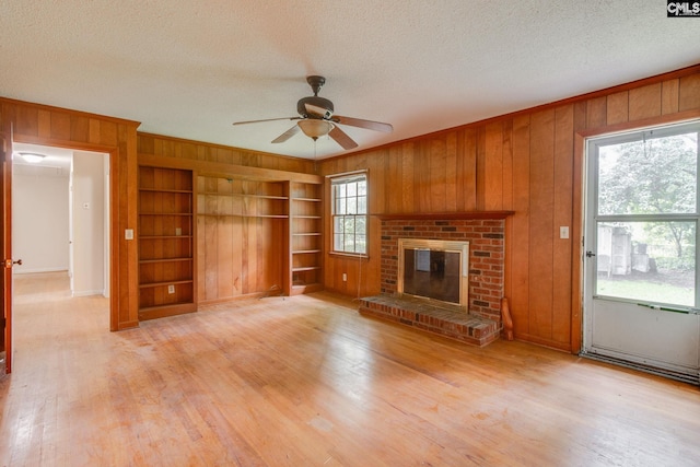 109 Garden Springs Rd, Columbia, SC 29209 - unfurnished living room with wooden walls, built in features, a textured ceiling, ceiling fan, and light wood-type flooring