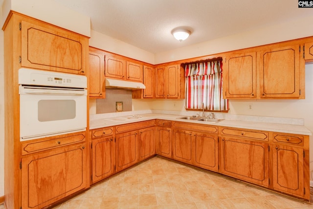 109 Garden Springs Rd, Columbia, SC 29209 - kitchen with white appliances, under cabinet range hood, light countertops, brown cabinets, and a textured ceiling