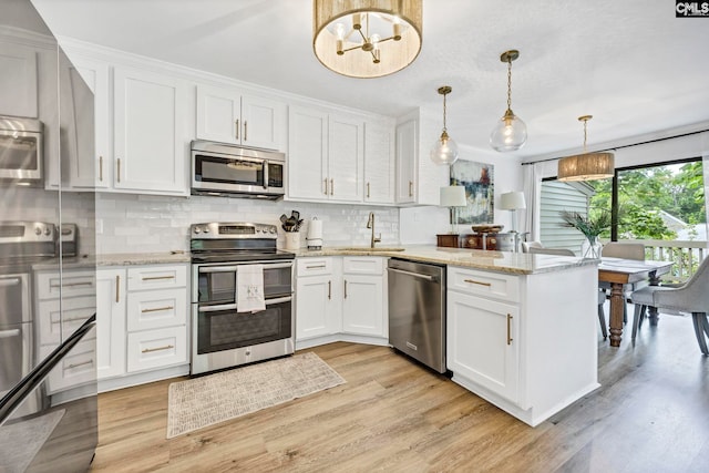 131 Leeward Rd, Columbia, SC 29212 - kitchen featuring appliances with stainless steel finishes, a peninsula, tasteful backsplash, and light wood-style floors