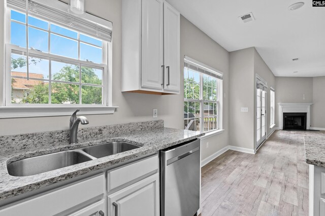 2 Alverston Ct, Irmo, SC 29063 - kitchen featuring stainless steel dishwasher, white cabinets, light wood-type flooring, a fireplace, and light stone countertops