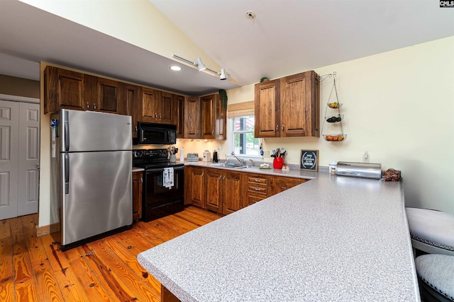 1326 Cedar Cove Rd, Camden, SC 29020 - kitchen featuring black appliances, a peninsula, light countertops, light wood finished floors, and recessed lighting