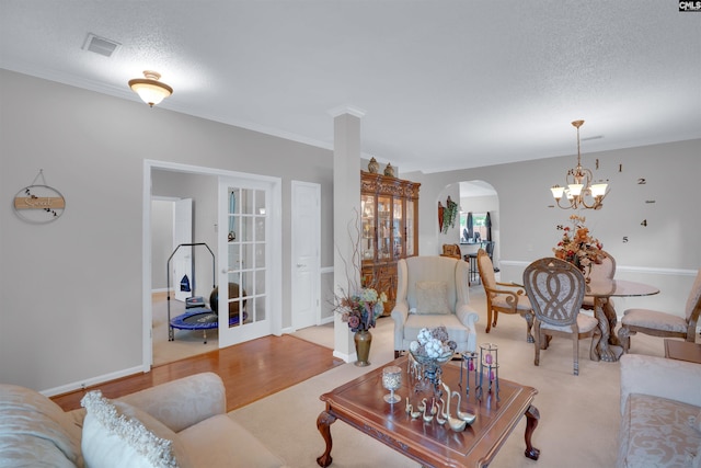 201 Summit Ridge Cir, Columbia, SC 29229 - living room featuring arched walkways, a textured ceiling, a chandelier, and light wood-type flooring