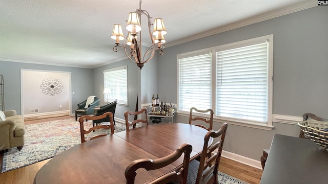 6965 Shelley Rd, Columbia, SC 29209 - dining space featuring ornamental molding, wood finished floors, a chandelier, healthy amount of natural light, and a textured ceiling