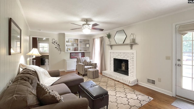 6965 Shelley Rd, Columbia, SC 29209 - living room featuring crown molding, a fireplace, a ceiling fan, and wood finished floors