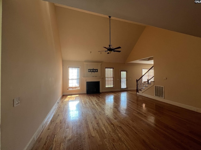 218 Scarborough Way, Lexington, SC 29072 - unfurnished living room featuring stairway, a ceiling fan, wood finished floors, high vaulted ceiling, and a fireplace