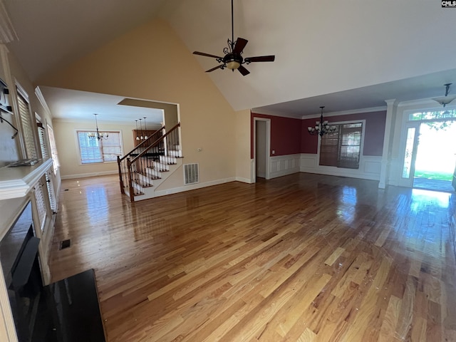 218 Scarborough Way, Lexington, SC 29072 - unfurnished living room featuring a chandelier, light wood-type flooring, wainscoting, high vaulted ceiling, and a decorative wall