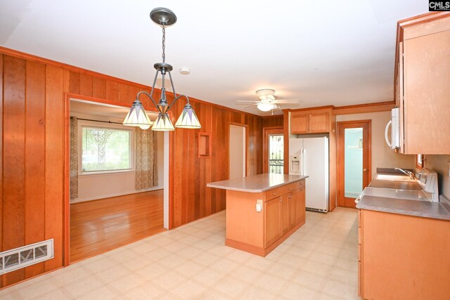 1120 Garden Ave, Cayce, SC 29033 - kitchen with white appliances, a center island, wood walls, light flooring, and a ceiling fan