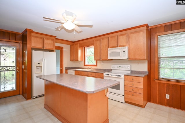 1120 Garden Ave, Cayce, SC 29033 - kitchen with white appliances, light floors, wood walls, a ceiling fan, and a center island