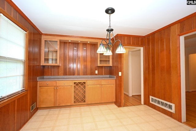 1120 Garden Ave, Cayce, SC 29033 - kitchen featuring light floors, light countertops, wood walls, ornamental molding, and glass insert cabinets