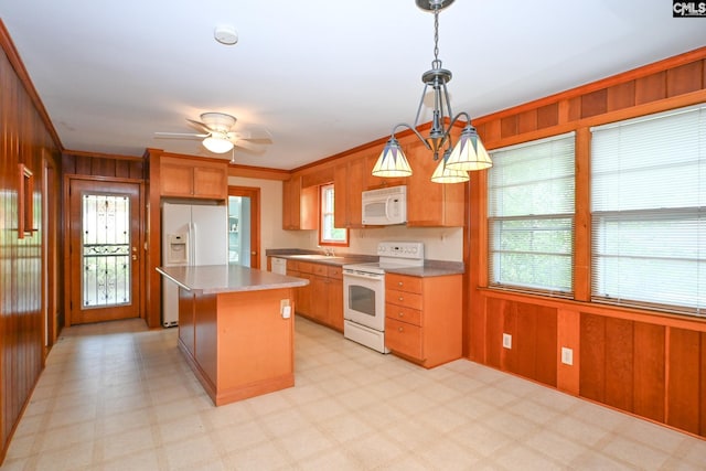 1120 Garden Ave, Cayce, SC 29033 - kitchen featuring white appliances, wooden walls, light flooring, a center island, and a ceiling fan