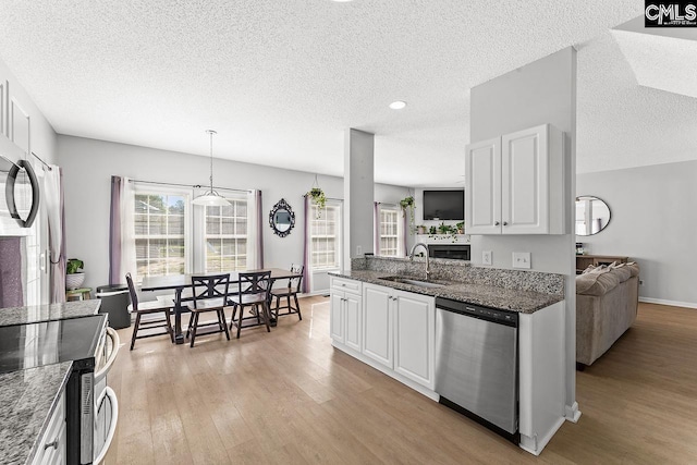 218 Founders Ridge Rd, Columbia, SC 29229 - kitchen with stainless steel appliances, light wood-style floors, a textured ceiling, white cabinetry, and dark stone countertops