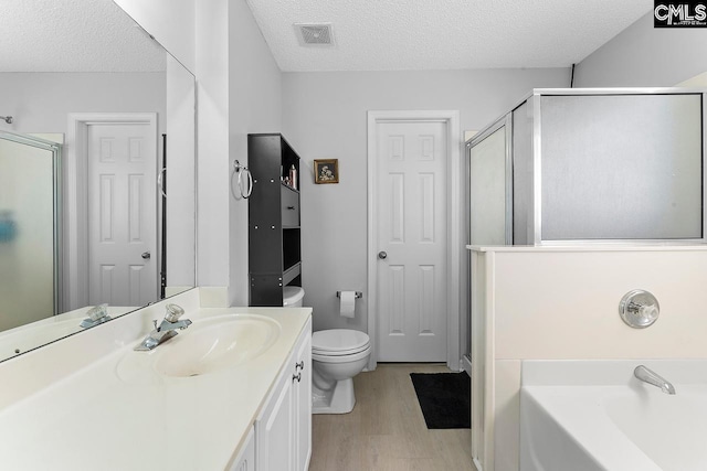 218 Founders Ridge Rd, Columbia, SC 29229 - bathroom featuring wood finished floors, a textured ceiling, a stall shower, a bath, and vanity