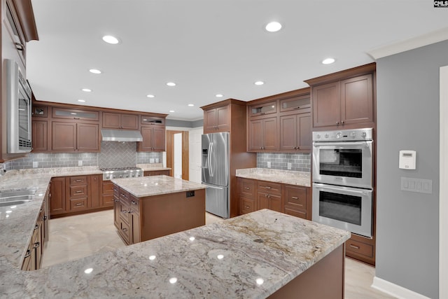 2432 Bermuda Hills Rd, Columbia, SC 29223 - kitchen featuring stainless steel appliances, under cabinet range hood, tasteful backsplash, glass insert cabinets, and light stone countertops