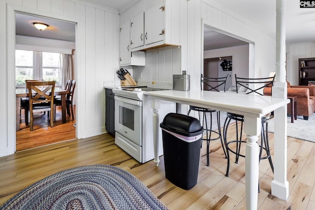 289 King Charles Rd, Columbia, SC 29209 - kitchen featuring electric range, ornamental molding, light wood-style floors, light countertops, and white cabinets