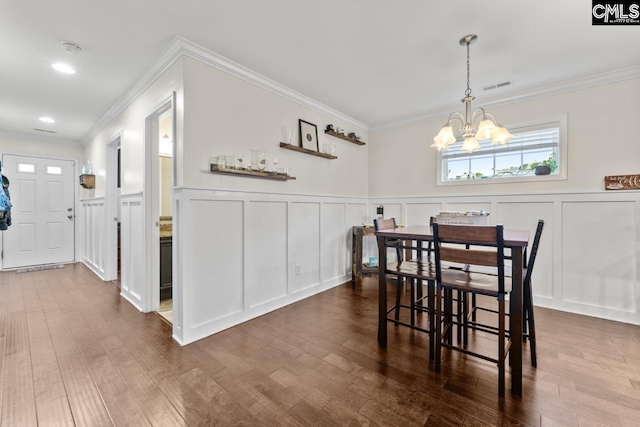 34 Riesling Ct, Lugoff, SC 29078 - dining room featuring a decorative wall, a chandelier, dark wood finished floors, wainscoting, and ornamental molding