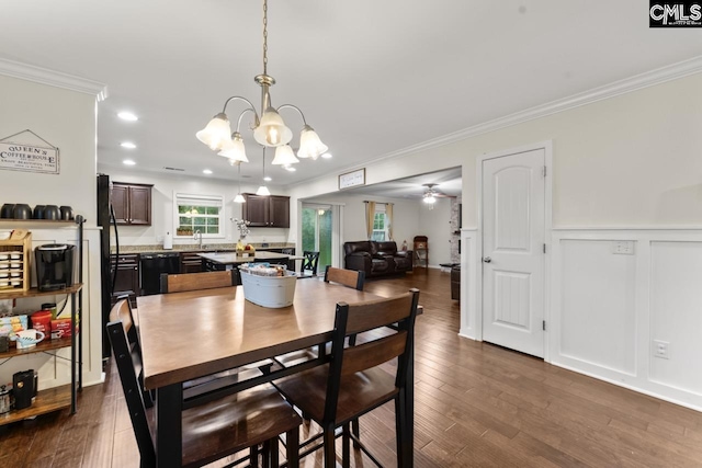 34 Riesling Ct, Lugoff, SC 29078 - dining area with crown molding, a chandelier, dark wood finished floors, wainscoting, and ceiling fan