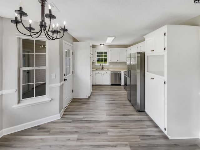1524 Highway Church Rd, Elgin, SC 29045 - kitchen featuring stainless steel appliances, a chandelier, white cabinets, light wood finished floors, and light countertops