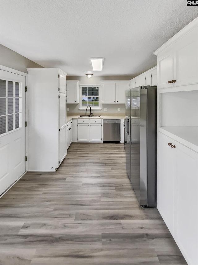 1524 Highway Church Rd, Elgin, SC 29045 - kitchen with appliances with stainless steel finishes, white cabinetry, light countertops, light wood-style flooring, and a textured ceiling