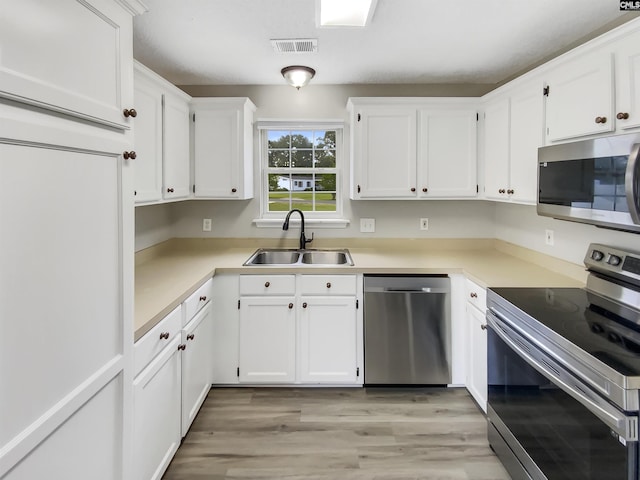 1524 Highway Church Rd, Elgin, SC 29045 - kitchen with stainless steel appliances, white cabinetry, light wood finished floors, and light countertops