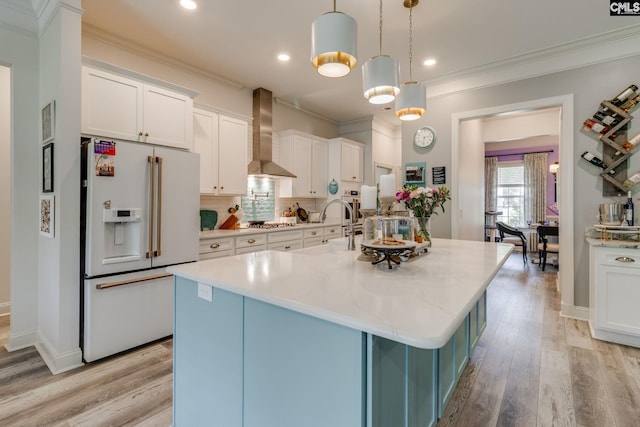 6150 Crabtree Rd, Columbia, SC 29206 - kitchen with white fridge with ice dispenser, wall chimney exhaust hood, white cabinetry, light wood-style flooring, and ornamental molding