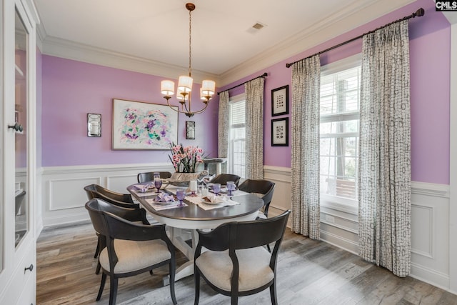 6150 Crabtree Rd, Columbia, SC 29206 - dining area with a wainscoted wall, a decorative wall, a chandelier, and wood finished floors