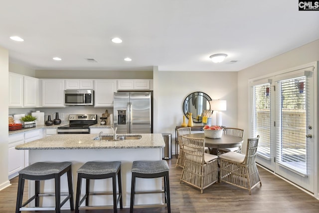 15 Ozark Dr, Columbia, SC 29223 - kitchen featuring appliances with stainless steel finishes, dark wood finished floors, white cabinets, light stone counters, and recessed lighting