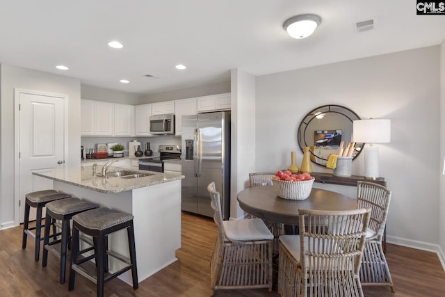 15 Ozark Dr, Columbia, SC 29223 - kitchen featuring appliances with stainless steel finishes, white cabinetry, dark wood finished floors, light stone counters, and recessed lighting
