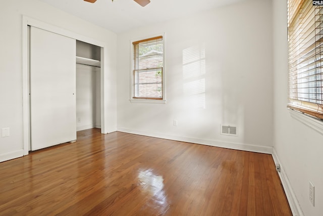 227 Latonea Dr, Columbia, SC 29210 - unfurnished bedroom featuring multiple windows, wood finished floors, a closet, and ceiling fan
