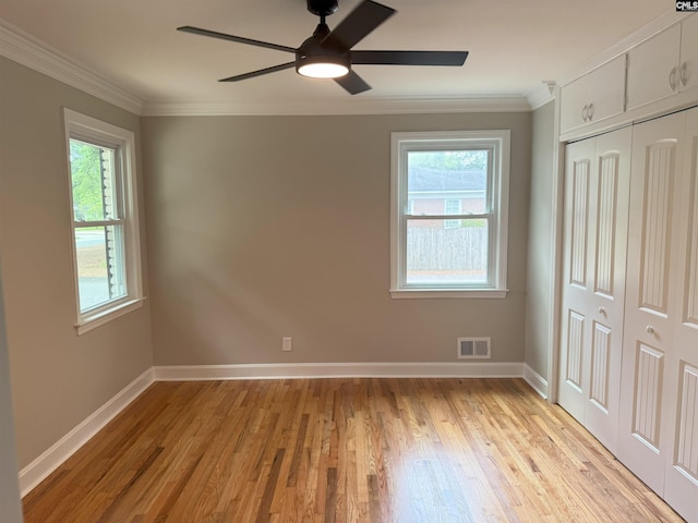 1341 Sanford Rd, Columbia, SC 29206 - unfurnished bedroom featuring multiple windows, light wood finished floors, a closet, ornamental molding, and ceiling fan