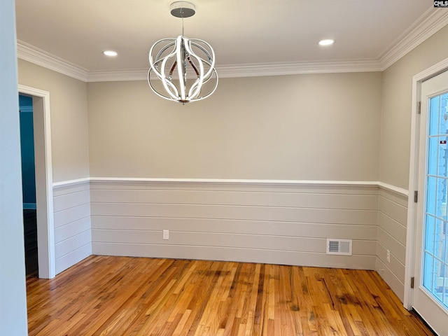 1341 Sanford Rd, Columbia, SC 29206 - empty room featuring a chandelier, light wood-type flooring, crown molding, wainscoting, and healthy amount of natural light