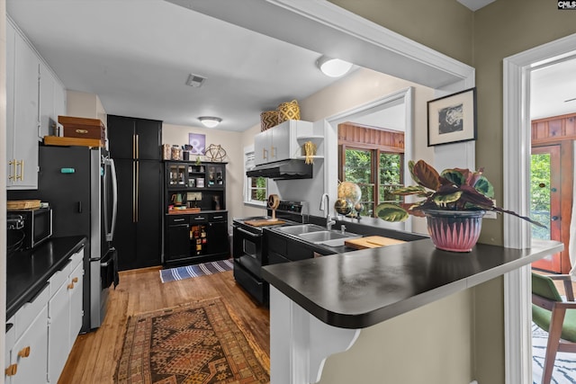 110 Summerlea Dr, Columbia, SC 29203 - kitchen with black appliances, under cabinet range hood, a peninsula, dark countertops, and open shelves