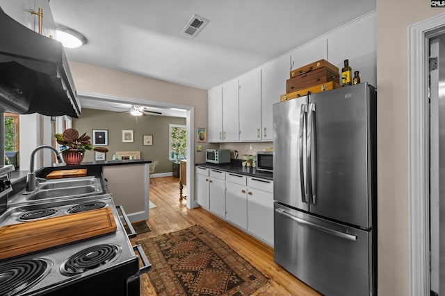 110 Summerlea Dr, Columbia, SC 29203 - kitchen featuring appliances with stainless steel finishes, light wood-type flooring, white cabinetry, and dark countertops