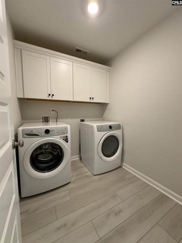 15 Runelle Ln, Columbia, SC 29229 - laundry area with washing machine and dryer, cabinet space, and light wood-type flooring
