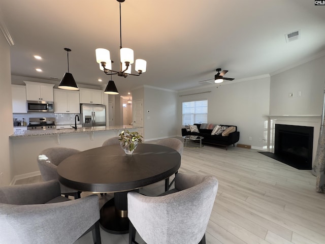 15 Runelle Ln, Columbia, SC 29229 - dining space featuring crown molding, light wood finished floors, a ceiling fan, a fireplace with flush hearth, and recessed lighting