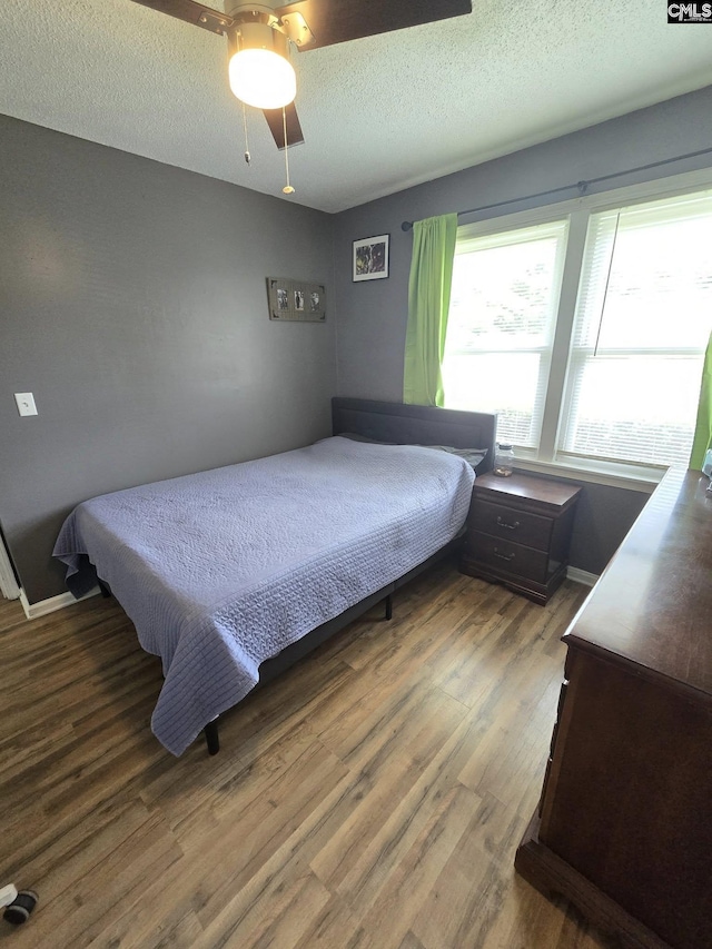 704 Cambridge, Lugoff, SC 29078 - bedroom featuring multiple windows, wood finished floors, a textured ceiling, and ceiling fan