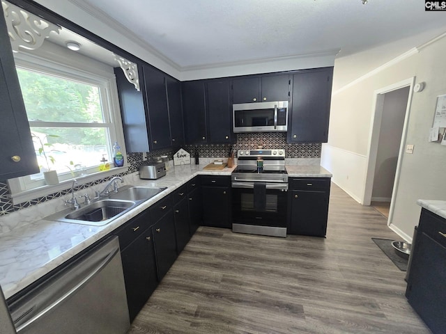 704 Cambridge, Lugoff, SC 29078 - kitchen with appliances with stainless steel finishes, dark cabinetry, tasteful backsplash, crown molding, and dark wood-type flooring