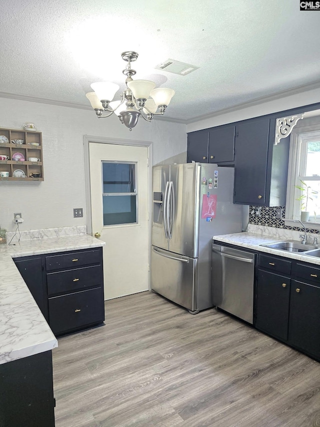 704 Cambridge, Lugoff, SC 29078 - kitchen featuring appliances with stainless steel finishes, a textured ceiling, a chandelier, light countertops, and light wood-type flooring