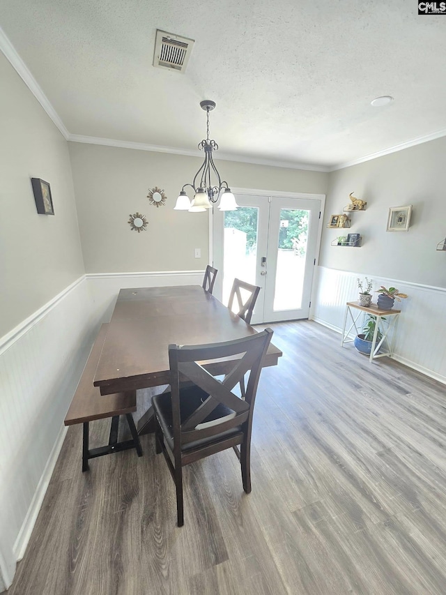704 Cambridge, Lugoff, SC 29078 - dining area featuring french doors, wood finished floors, a textured ceiling, crown molding, and wainscoting